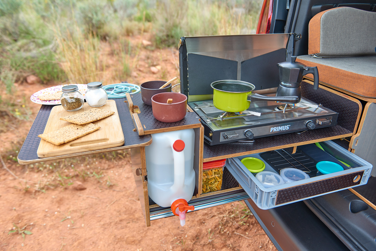 Módulo cocina abierto con cocina portátil de gas para camping.